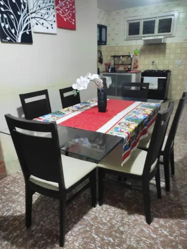 Mesa de jantar com 6 cadeiras com tampo de vidro e base em travertino