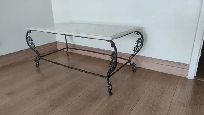 mesa de centro com tampo de mármore e pés de metal