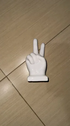 escultura de cerâmica em formato de sinal de paz e amor