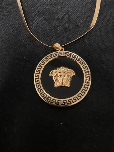 Colar dourado medusa fundo preto inspirado na Versace 
