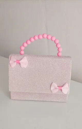 Bolsa de mão infantil rosa com detalhes em laço