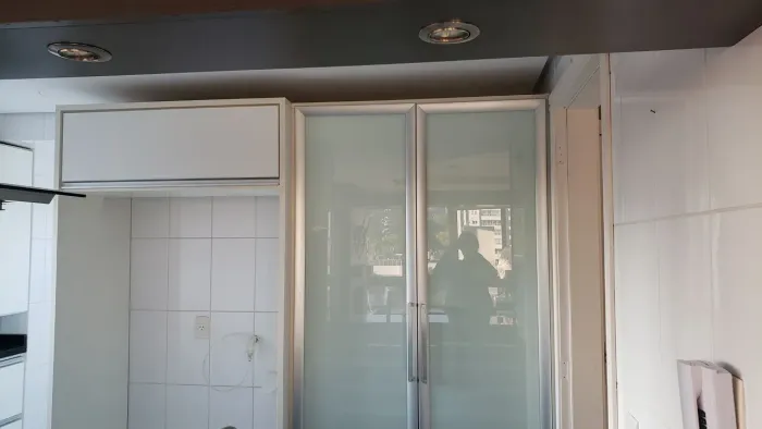 Armários de cozinha planejados em MDF branco com portas de vidro fosco