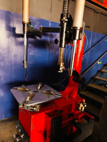 Máquina de desmontar pneu com braços auxiliares