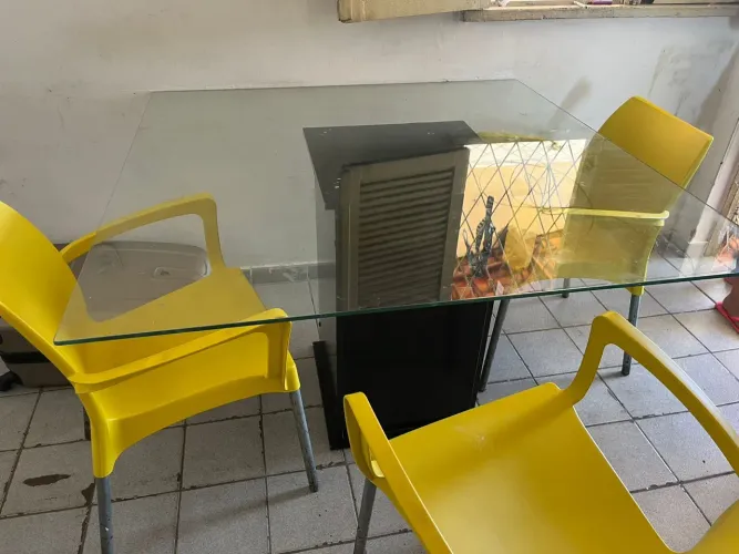 Mesa com tampo de vidro e 4 cadeiras. Com algumas marcas de uso, mas muito conservada.