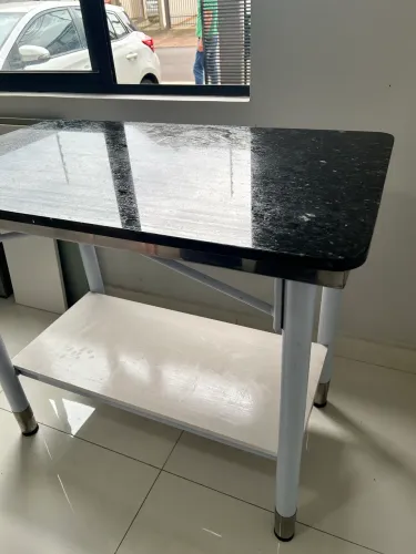 Mesa de inox, com tampo de granito sobreposto, 1,40 x 90 x 93cm.