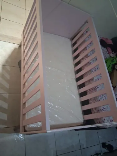 Berço rosa que vira cama com o colchão 