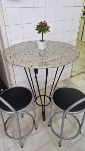 Mesa de granito e bancos de apoio.