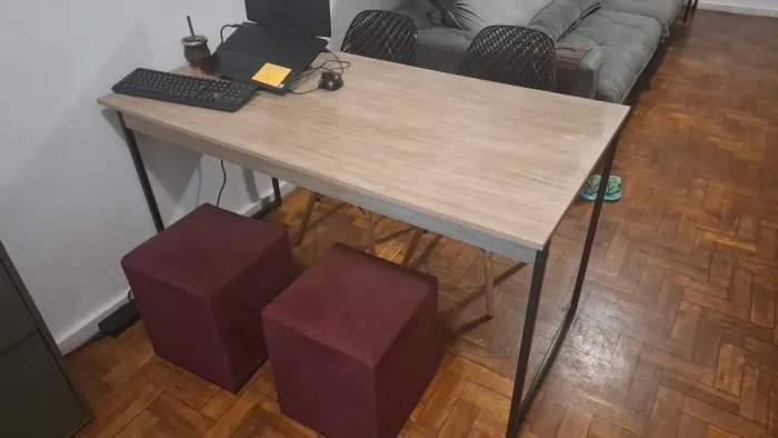 Mesa estilo industrial com cadeiras e puffs