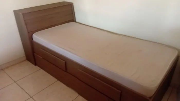 Cama com baú, colchão, gavetas e cama auxiliar. 