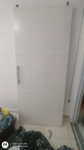 Porta de correr em madeira laminada, com carretilha em aço instalada, e trilho de alumínio