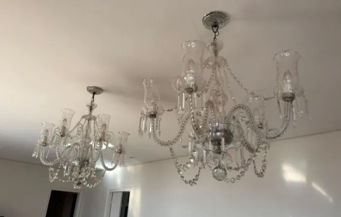 Par de lustre de cristal clássico com cinco ou oito braços curvos e pingentes facetados.