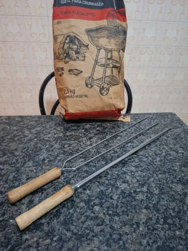 Espetos de churrasco e carvão vegetal