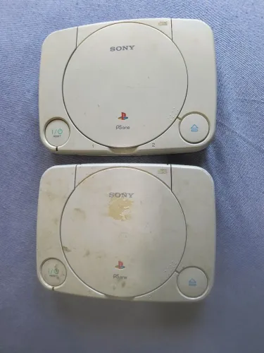 PlayStation 1 dois consoles para consertar. Um o problema é o leitor o outro apenas a mola
