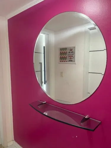 Espelho bisotado com prateleira de vidro. 