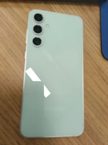 Samsung S23 Fe verde no plastico ao redor.