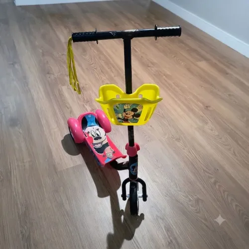Patinete infantil de três rodas com cestinha.