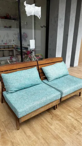 Vendo poltronas com estrutura de madeira e tecido linho azul claro. 
