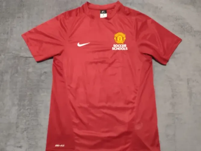 Camisa Oficial Manchester United Soccer Schools, tamanho P (49x71cm).