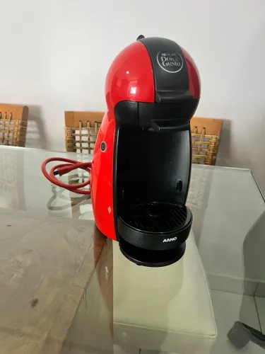 A cafeteira mostrada na imagem é uma Nescafé Dolce Gusto Piccolo da Arno na cor vermelha.