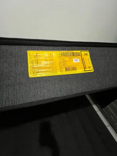 cama box de casal com colchão alto, de molas, e base preta.