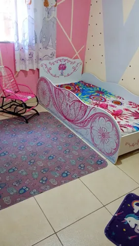 Cama infantil com colchão bicicleta e cadeira de balanço.