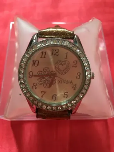 Relógio com pulseira em cor ouro velho e caixa prateada com strass