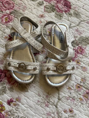 sandálias infantis Michael Kors brancas e prateadas.