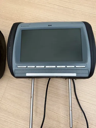 Encosto de cabeça para automóvel com tela e leitor de DVD integrados.