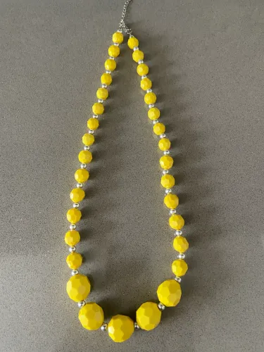 Colar de contas amarelas facetadas com design que varia o tamanho das esferas