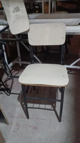 Cadeiras escolares tradicionais, com pés de ferro.