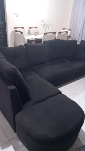 Um sofá L grande com pulf 
