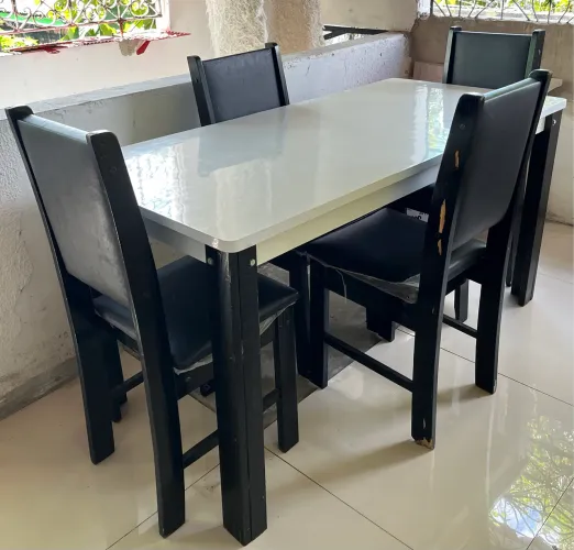 Conjunto de mesa com 4 cadeiras em fórmica branca.
