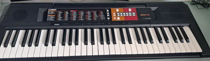 Teclado Yamaha PSR-F51, com capa de proteção, fonte original e apoio de partitura.