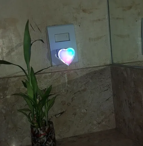 Abajur de tomada em formato de coração. Em plástico branco e luz colorida 