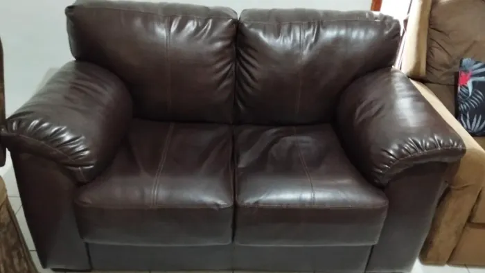 Sofá marrom escuro de couro puro de dois lugar bem  o valor dele estou pedindo r$ 350