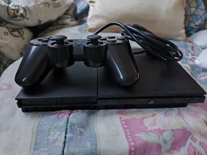 PlayStation 2, com um controle original, jogos, memory card e cabos.