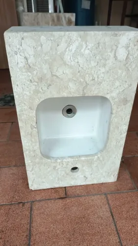 Lavatório de mármore travertino com cuba de cerâmica.