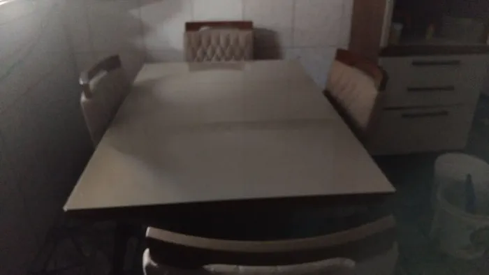 Mesa de sala,com quatro cadeiras tampa de vidro em côr bege.