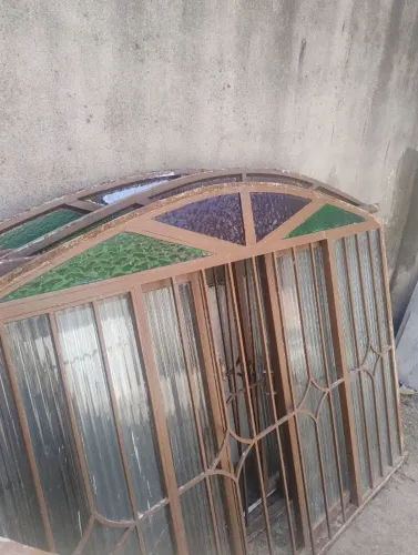 Janela de Ferro Antiga com Grade e Vitral Colorido em Arco