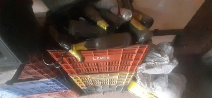  cinco engradados com garrafas de cervejas.
