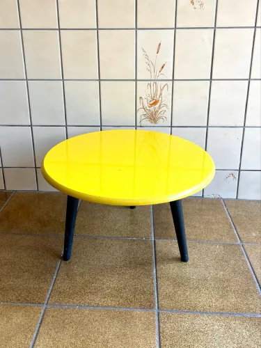 Mesa de apoio redonda amarela com 3 pés pretos