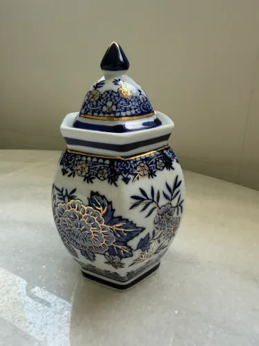 Potiche antigo oriental de porcelana branca e azul com detalhes em dourado.