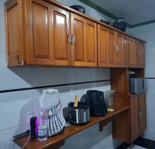 Armário aéreo de cozinha com bancada de apoio e nicho para eletrodomésticos.