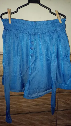 Short 95% poliester, 5% elastano, com elástico na cintura e cinto do mesmo tecido.