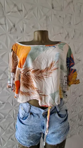 Blusa cropped ampla com amarração frontal e estampa de folhagem tropical