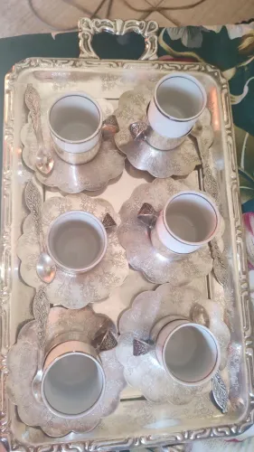 Jogo de café, banhado em prata com detalhes nas colheres, pratinhos e bandeja. Elegante,