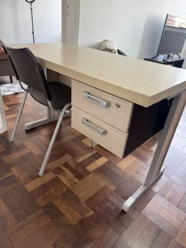 Mesa de escritório retangular e cadeira de plástico.