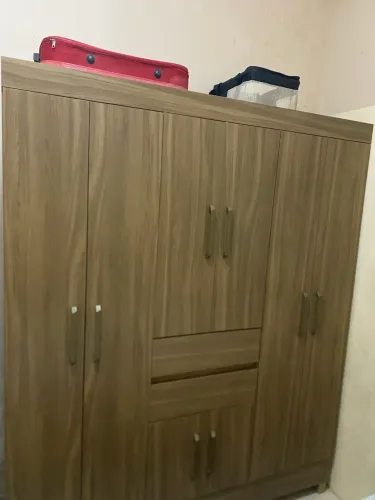 Guarda-roupa amplo em padrão madeira, com 8 portas, 2 gavetas centrais e puxadores.