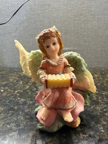 estátua antiga de anjo com piano- rosa e laranja