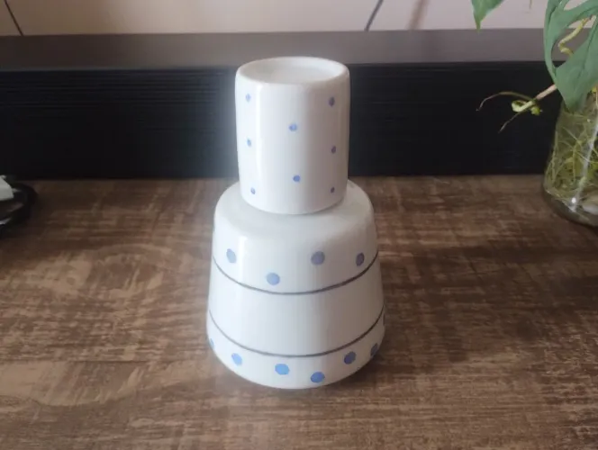 Moringa de cerâmica com estampa de bolinhas azuis é um objeto colecionável charmoso.